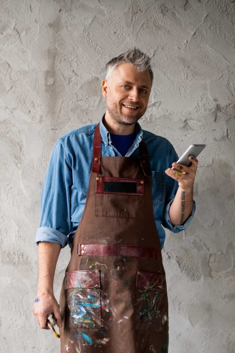 happy-and-successful-painter-with-smartphone-and-paintbrush