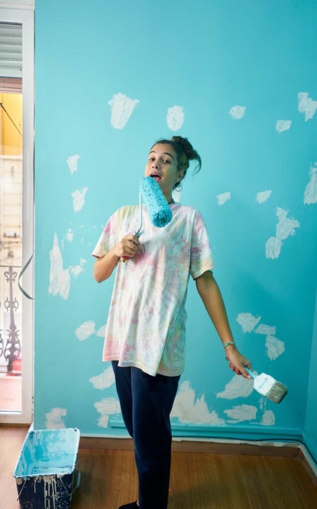 happy-woman-painting-interior-wall-with-paint-roller-in-new-house 1